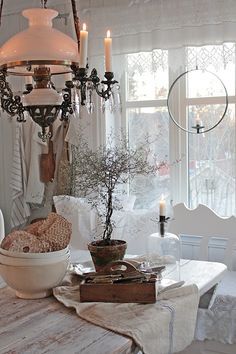 a chandelier hanging from the ceiling in a dining room next to a table