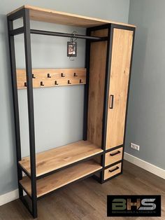 a wooden and metal shelf with hooks on the bottom, two shelves below it that are open