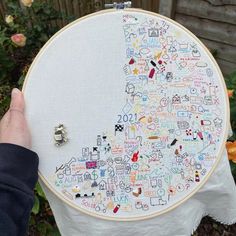 someone is holding up a large embroidery hoop