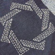 a close up of a blue jean jacket with white stitching on the front and back