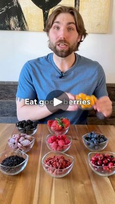 a man sitting at a table with bowls of fruit and berries in front of him