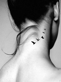 a woman's neck tattoo with birds flying in the sky on her left side