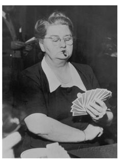 an old black and white photo of a woman holding playing cards in her right hand