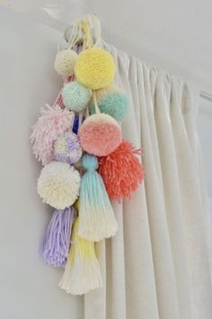 multicolored pom - poms hanging on the curtain