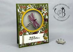 a card with a dragonfly on it and a silver broochle next to it