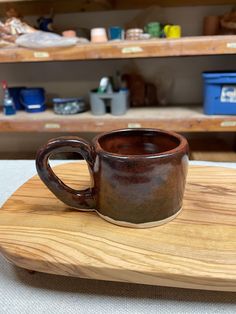 a coffee cup sitting on top of a wooden board