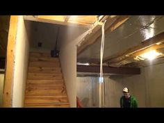 a man standing next to a set of stairs in a room that is under construction