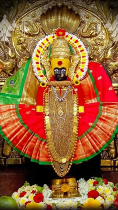 an idol is displayed in front of a gold statue