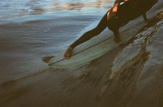 a man sitting on top of a surfboard in the ocean next to a wave