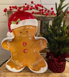 a ceramic gingerbread man next to a potted christmas tree