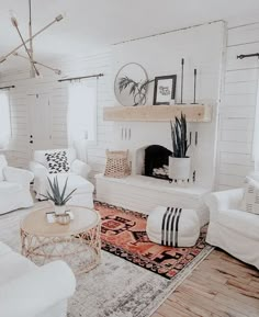 a living room filled with white furniture and a fire place