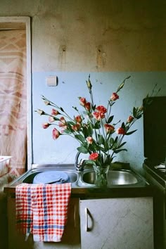 a kitchen with a sink, stove and flowers