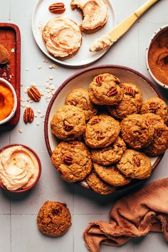 a bowl filled with cookies next to bowls of peanut butter and pecans on a table