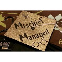 a gold graduation cap with the words,'mischef managed'on it