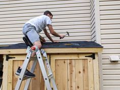 a man working on the roof of a house with a hammer and an adjustable ladder