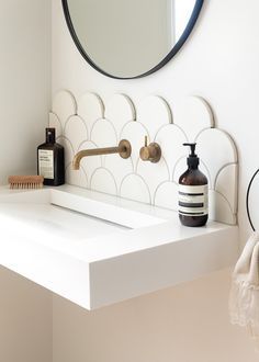 a bathroom with a sink, mirror and soap dispenser on the counter