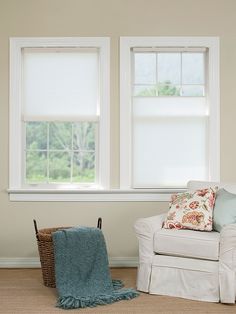 a living room with two windows and a chair