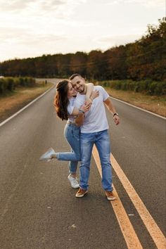 two people are walking down the road with their arms around each other and one person is hugging