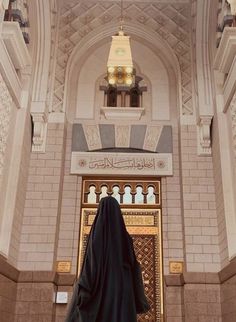 a person in a black robe standing at the entrance to a building