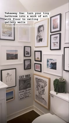 a white toilet sitting in a bathroom next to a wall with pictures on the walls