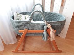 a baby's crib with a wooden handle and tassels