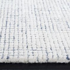 a white rug with blue and gray designs on it's edges is shown in close up