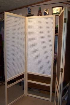 the room divider is made out of wood and has white pegboard on it