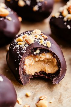 chocolate covered doughnuts with nuts and peanut butter on the top one is cut in half