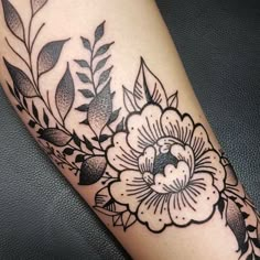 a black and white flower tattoo on the leg