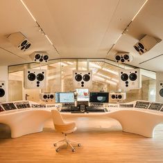 a recording studio with several monitors and chairs