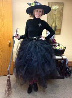 a woman wearing a witch costume and holding a broom