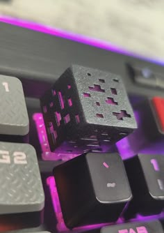 a black and pink computer keyboard with some dices on it's backlit keys