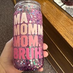 a hand holding a purple glittered cup with the words ma momm on it