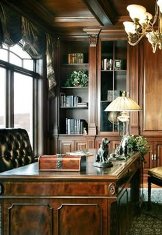 an office with wood paneling and chandelier above the desk, along with a leather chair