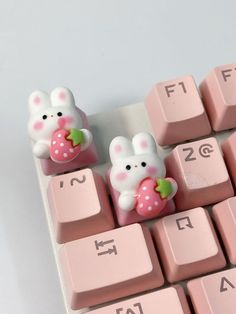 pink keyboard with two small white rabbits on it