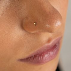 a woman's nose with a tiny gold star piercing on the tip of her nose