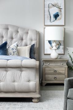 a white bed sitting next to two framed pictures