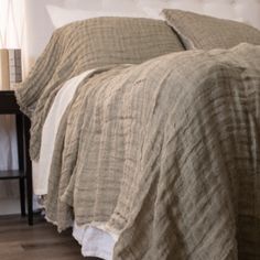 a bed with a white headboard and beige bedspread