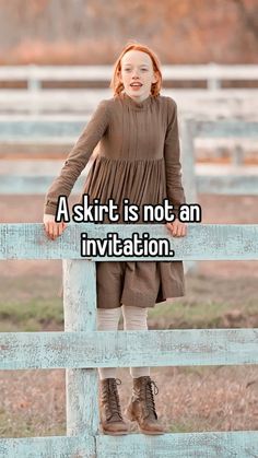 a girl standing on top of a wooden fence with the words, a skirt is not an