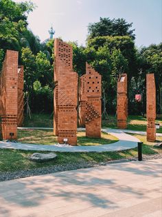 sculptures in the middle of a park with grass and rocks on either side of them