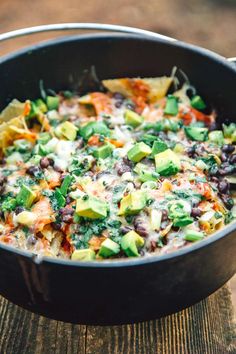 a skillet filled with black beans, avocado and tortilla chips