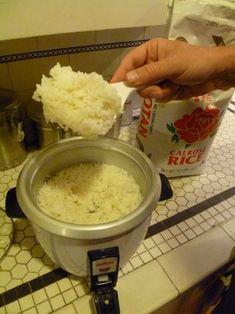 rice is being cooked in an electric rice cooker with a can of rice next to it