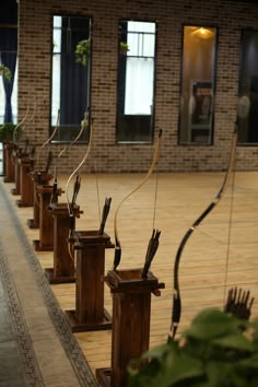 there are many wooden bow holders with arrows in them on the floor next to each other