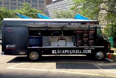 a black food truck parked in a parking lot