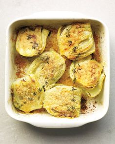 an overhead view of cooked zucchini in a casserole dish with herbs