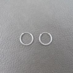 A great pair of simple, everyday wear Sterling Silver Hoops.These hoops measure 12mm.They are made of sterling silver and are great for those with sensitive ears.Mix and match with my other stud and hoop earringsThis listing is for one pair (2 pieces). Guys Ear Piercings, Hoop Earrings Aesthetic, Simple Silver Earrings, Small Silver Hoop Earrings, Simple Hoop Earrings, Tiny Hoop Earrings, Pretty Jewelry Necklaces, Simple Stud Earrings, Jewelry Aesthetic