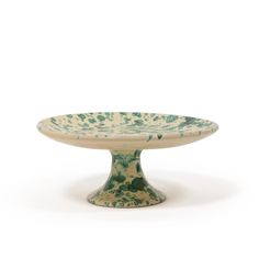 a green and white bowl sitting on top of a table