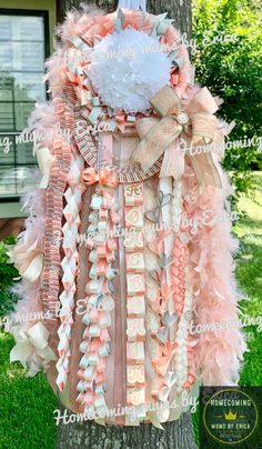 a pink and white dress hanging from a tree