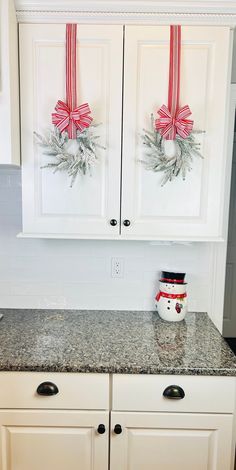 a kitchen with white cabinets and christmas decorations