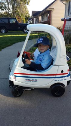 a young boy in a toy car on the street